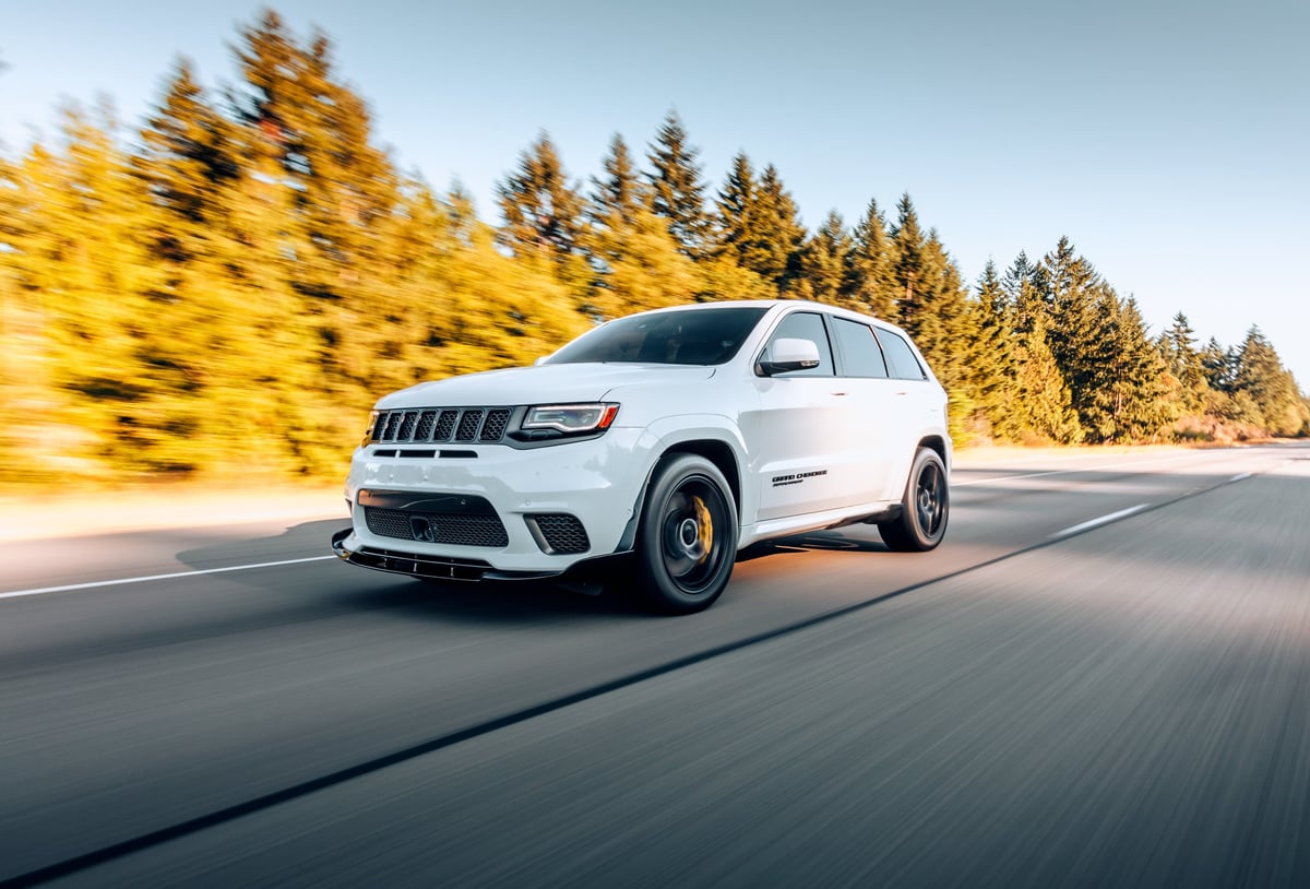 A modern SUV driving on a clean suburban American street